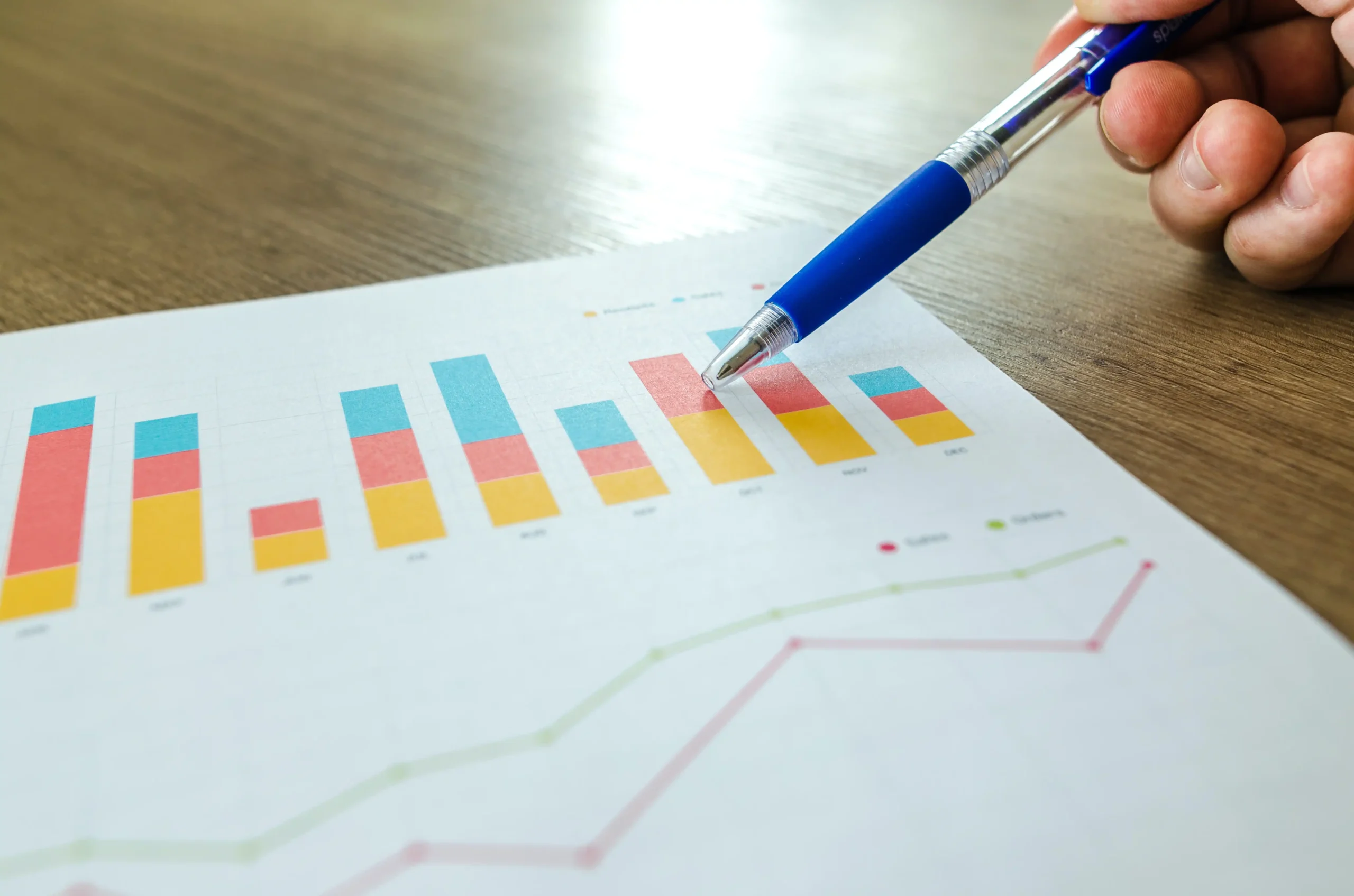 Pen pointing to a bar graph on paper